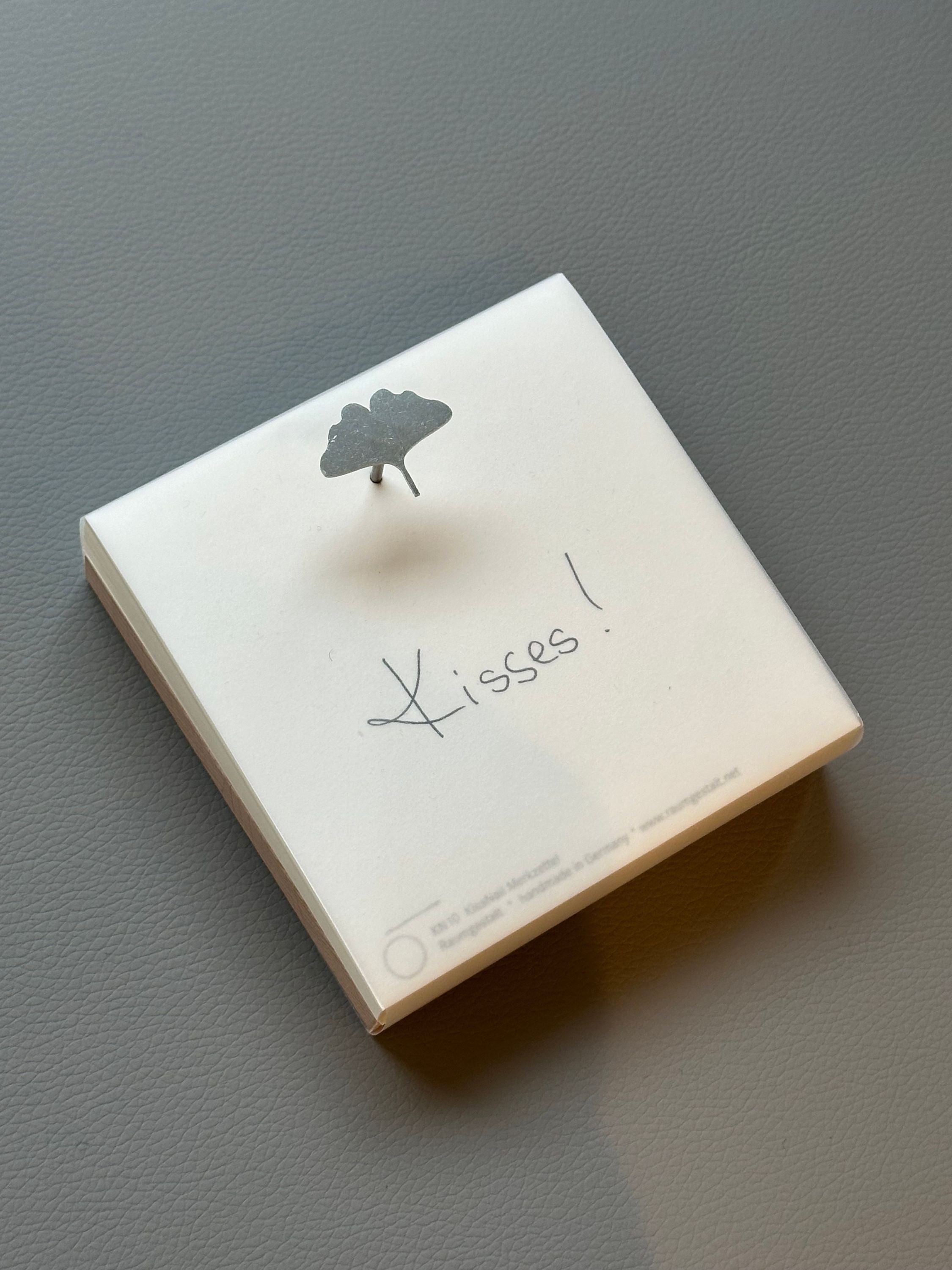 Merkzettel auf Eichenklotz „Kisses“